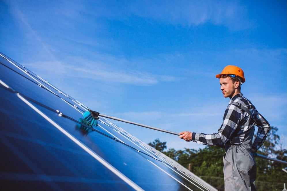 a person cleaning a solar panel